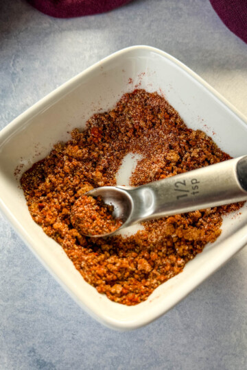 spices for rib dry rub in a white bowl with a spoon