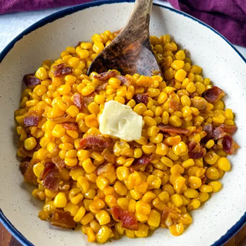 Southern fried corn with butter and bacon in a white bowl