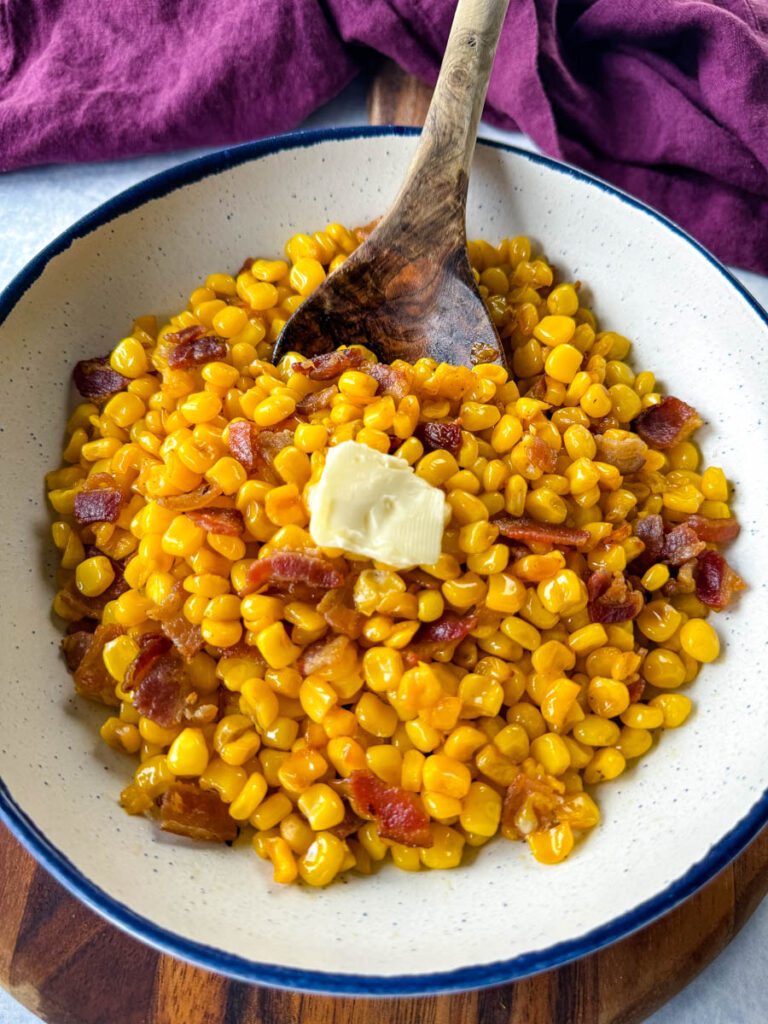 Southern fried corn with butter and bacon in a white bowl