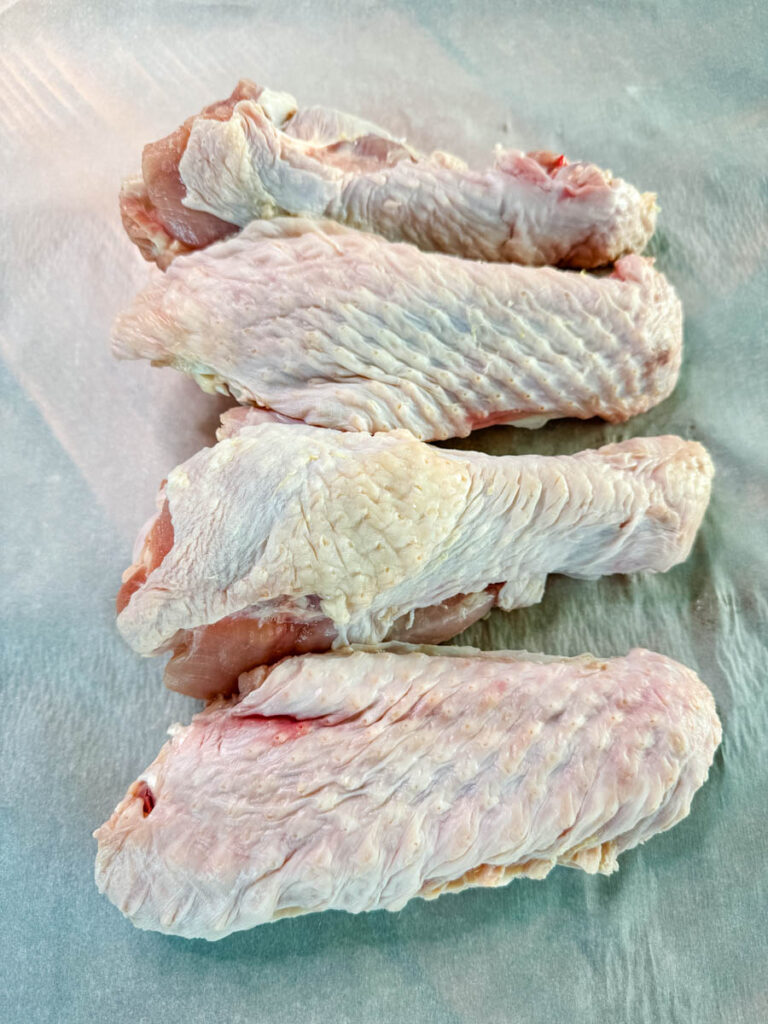 raw turkey wings on parchment paper