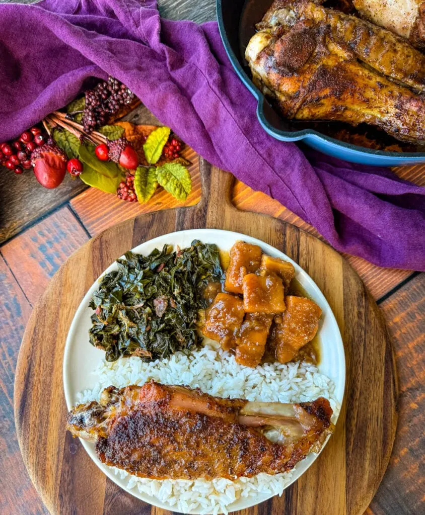 baked turkey wings on a plate with collard greens, sweet potatoes, and white rice