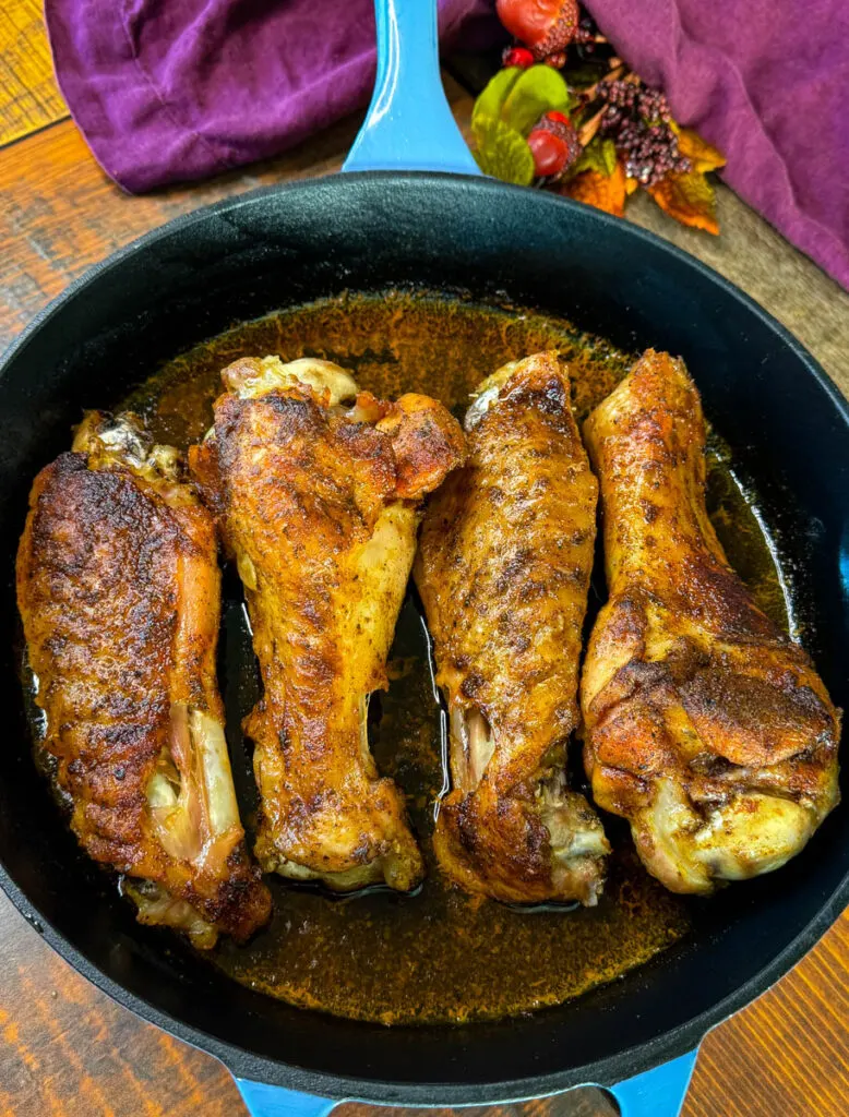 baked turkey wings in a cast iron skillet with chicken broth