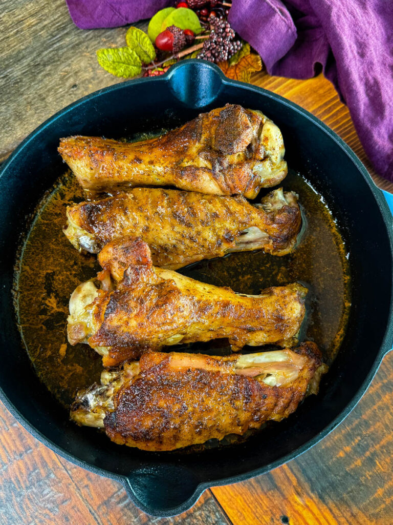 baked turkey wings in a cast iron skillet with chicken broth