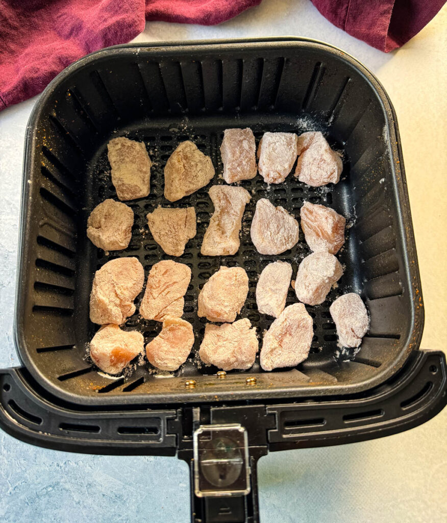 raw chicken breast pieces in an air fryer