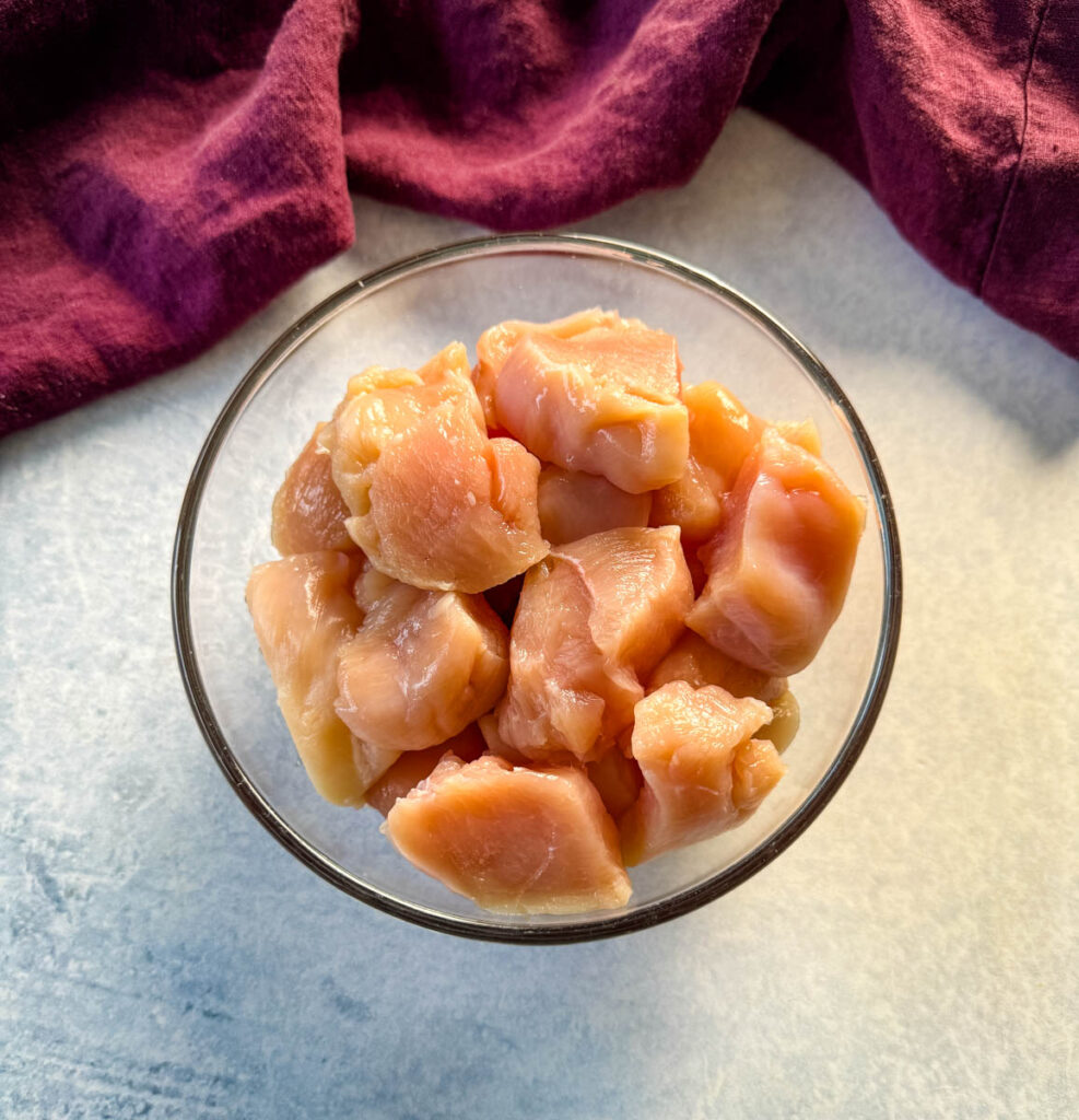 raw sliced chicken breast pieces in a glass bowl