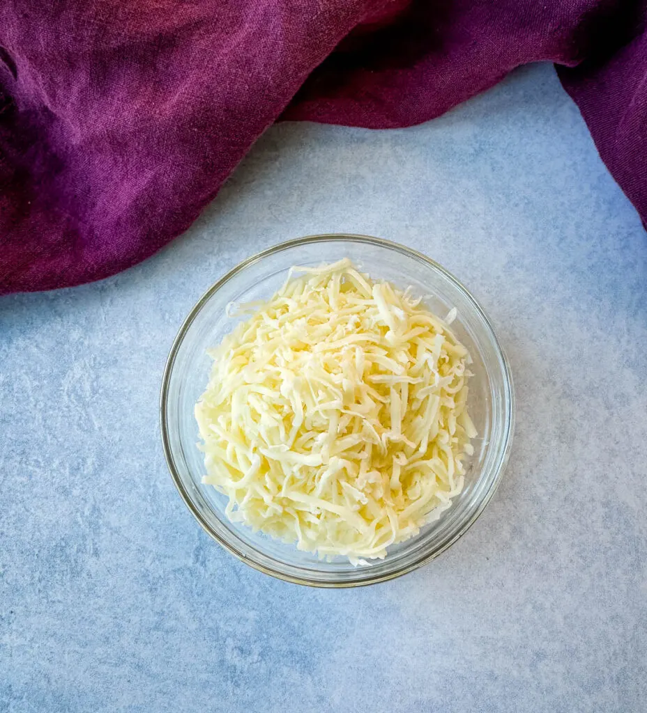 grated mozzarella cheese in a glass bowl