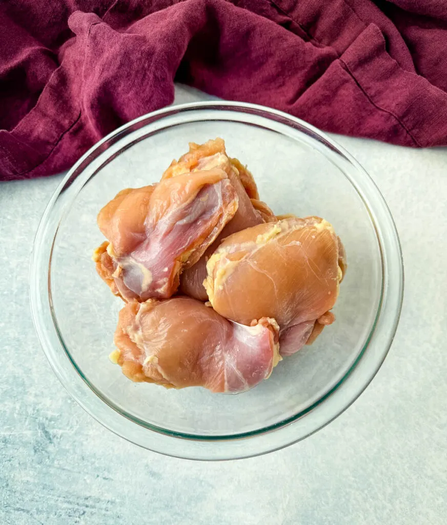 raw chicken thighs in a glass bowl