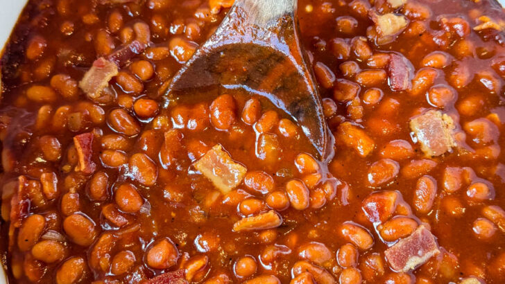 baked beans in a slow cooker Crockpot with a wooden spoon