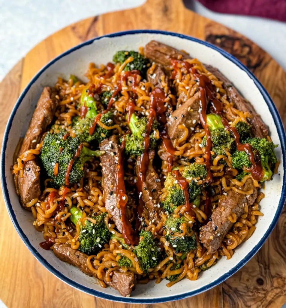 beef and broccoli stir fry with ramen noodles in a white bowl