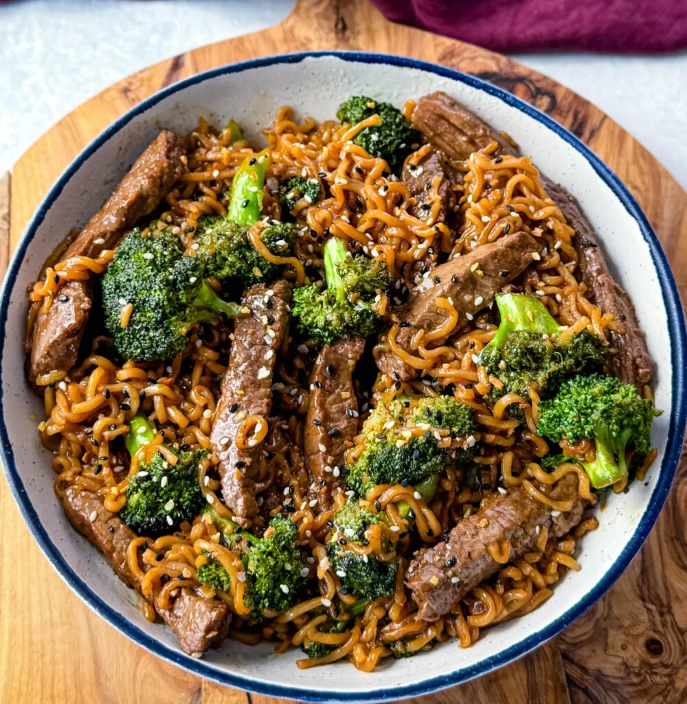 beef and broccoli stir fry with ramen noodles in a white bowl