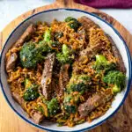 beef and broccoli stir fry with ramen noodles in a white bowl