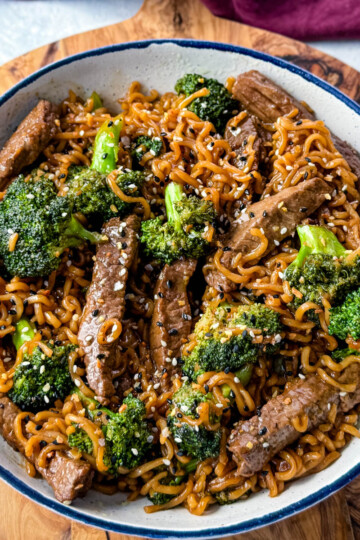 beef and broccoli stir fry with ramen noodles in a white bowl