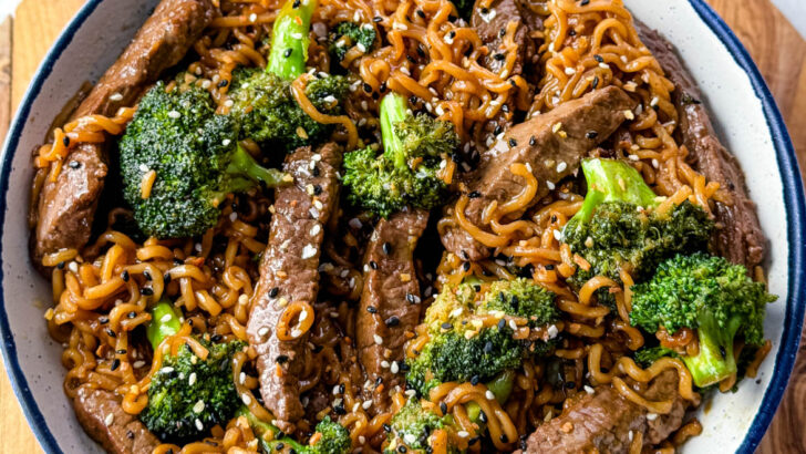 beef and broccoli stir fry with ramen noodles in a white bowl