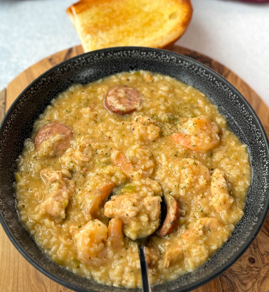 Cajun jambalaya soup in a black bowl with a piece of French bread