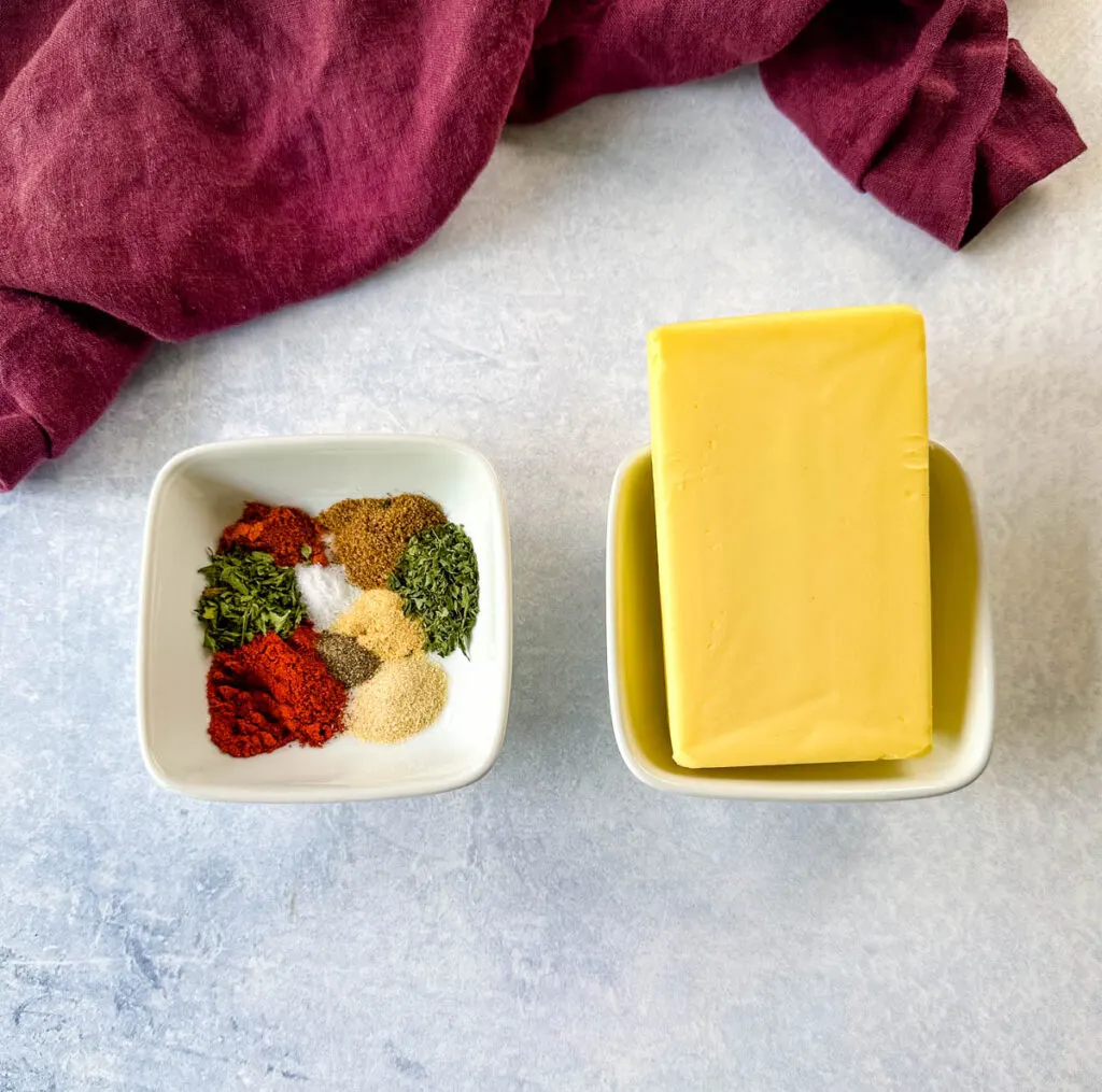 a stick of butter and Cajun spices in separate white bowls