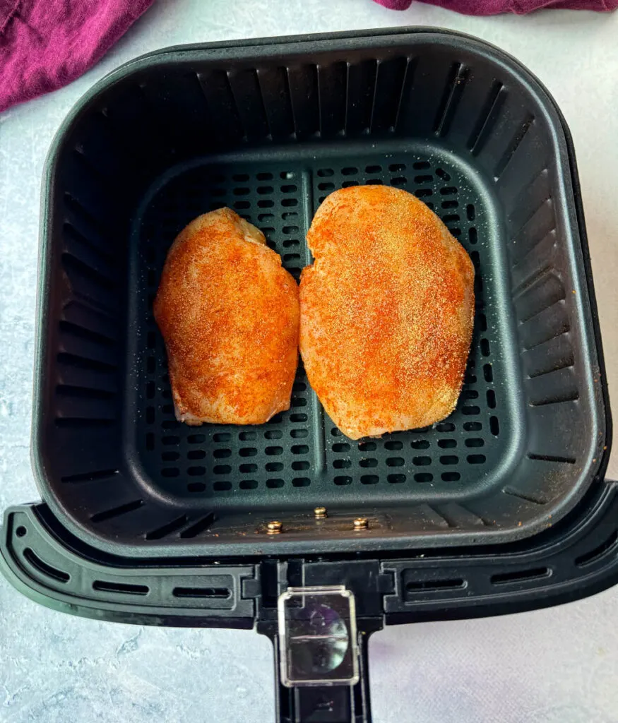 raw seasoned chicken breasts in an air fryer