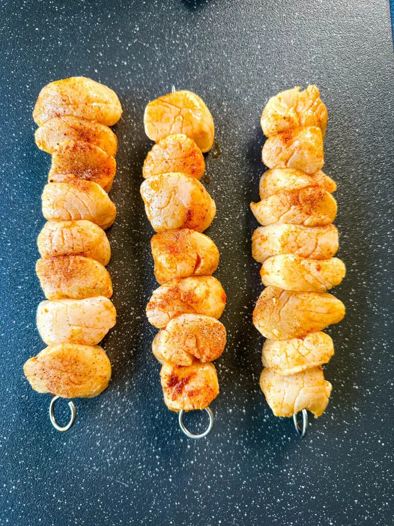 raw seasoned scallops on a sheet pan