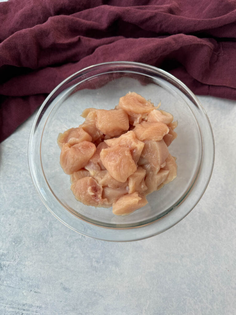 chunks of raw chicken breast in a glass bowl