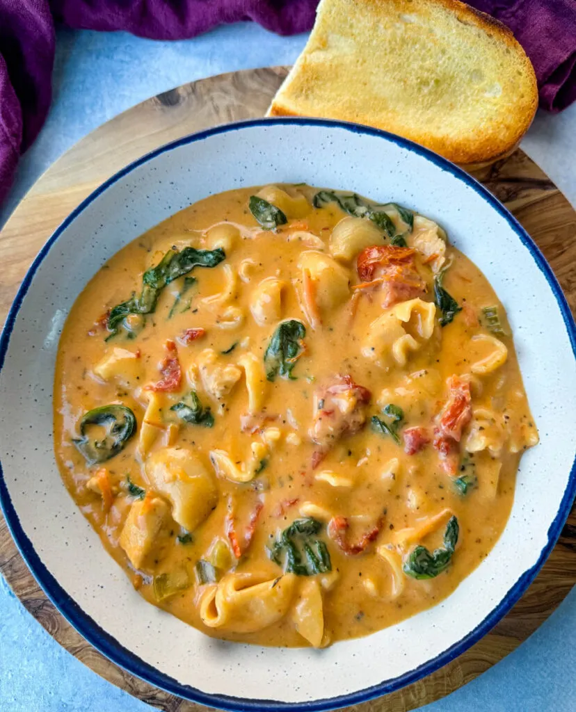 marry me Tuscan chicken soup in a white bowl with a piece of bread