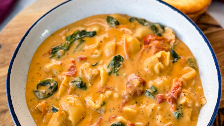 marry me Tuscan chicken soup in a white bowl with a piece of bread