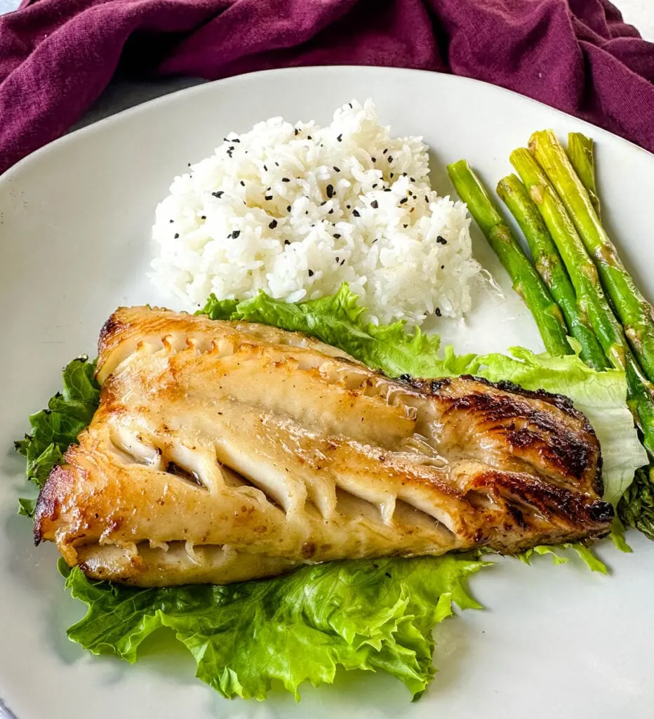 Nobu miso black cod on a plate with white rice and asparagus