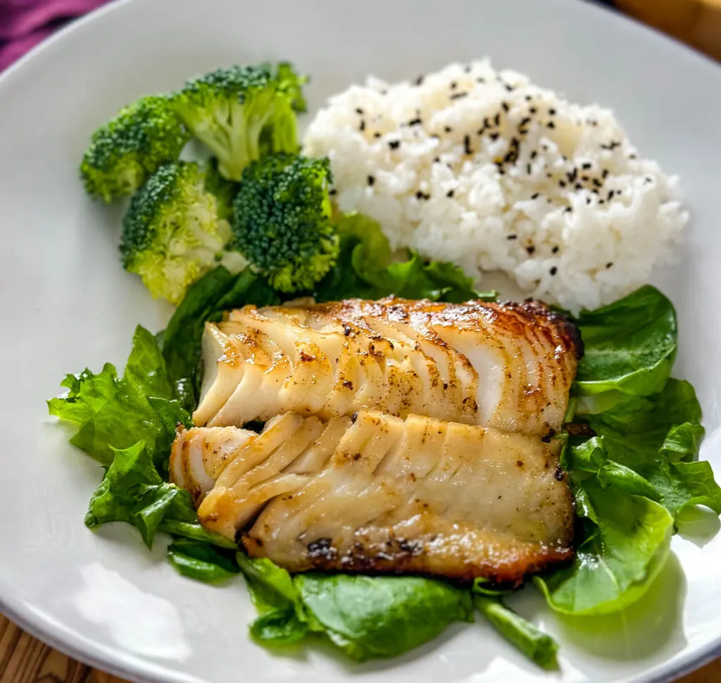 Nobu miso black cod fish on a plate with rice and greens