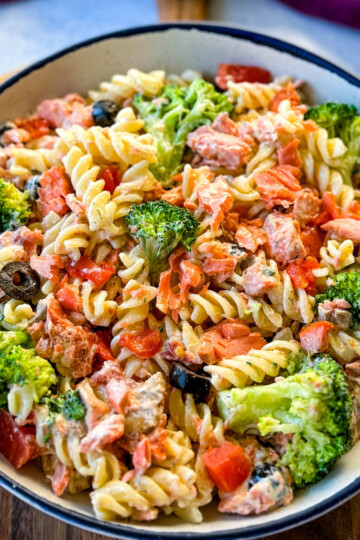 salmon pasta salad with broccoli and tomatoes in a white bowl