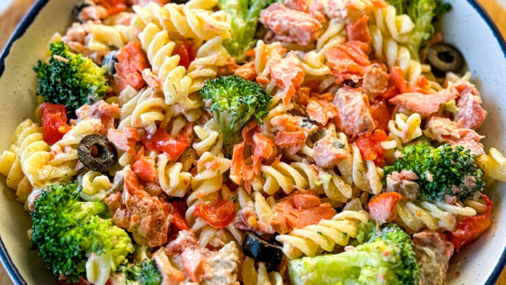 salmon pasta salad with broccoli and tomatoes in a white bowl