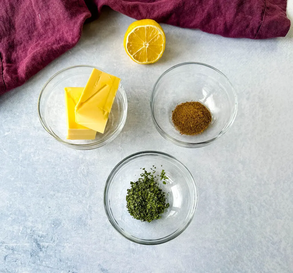 butter, lemon, Old Bay, smoked paprika, and parsley in separate glass bowls