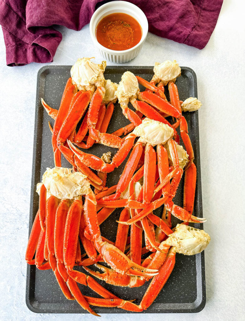 smoked crab legs on a sheet pan with smoky garlic butter