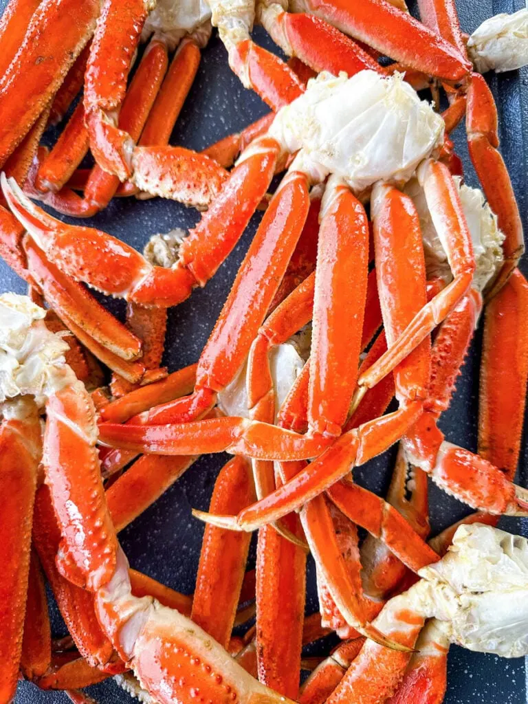 smoked crab legs on a sheet pan with smoky garlic butter