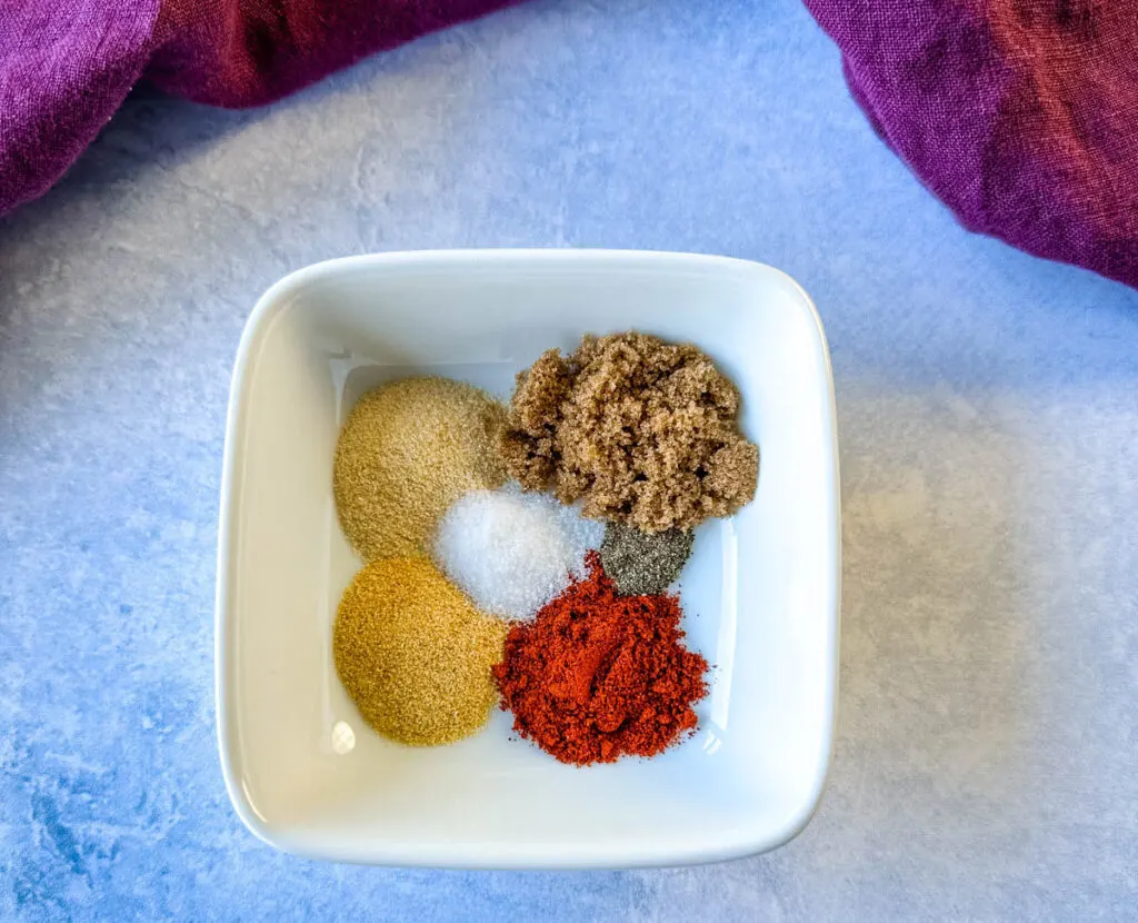 garlic powder, onion powder, brown sugar, smoked paprika, and salt in a white bowl