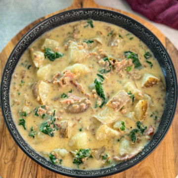 Italian sausage soup with potatoes and kale in a black bowl