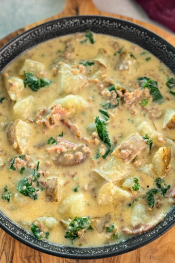 Italian sausage soup with potatoes and kale in a black bowl