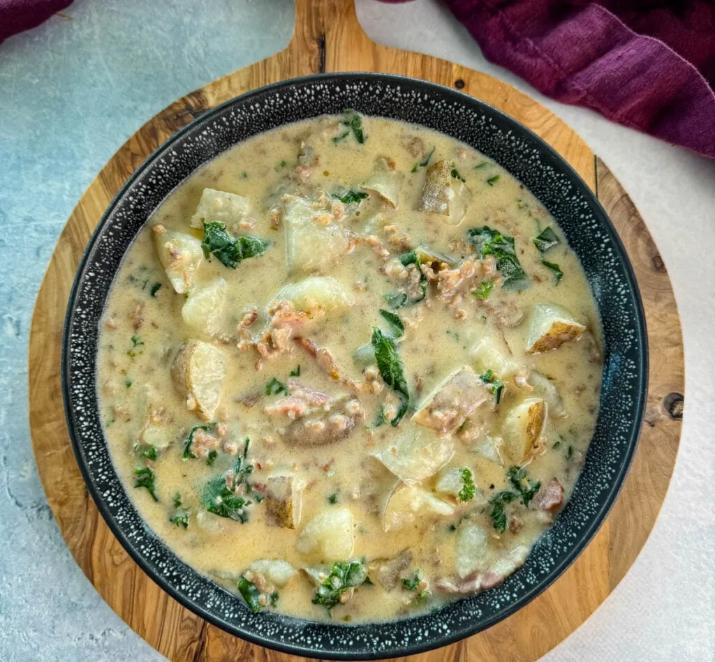 Italian sausage soup with potatoes and kale in a black bowl