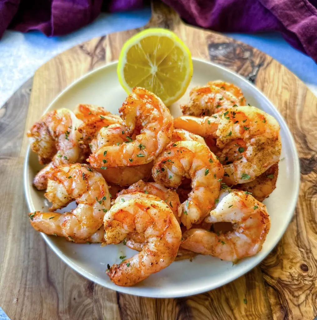 steamed and seasoned shrimp on a plate with fresh lemon