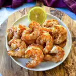 steamed and seasoned shrimp on a plate with fresh lemon