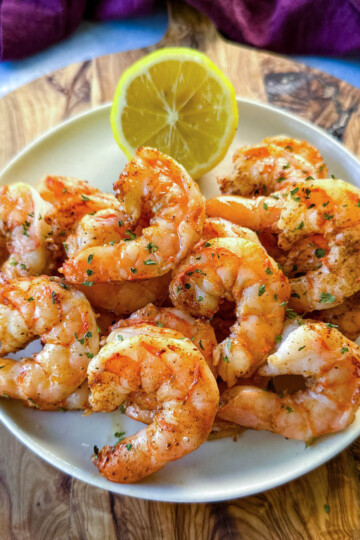 steamed and seasoned shrimp on a plate with fresh lemon