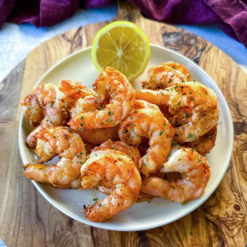 steamed and seasoned shrimp on a plate with fresh lemon