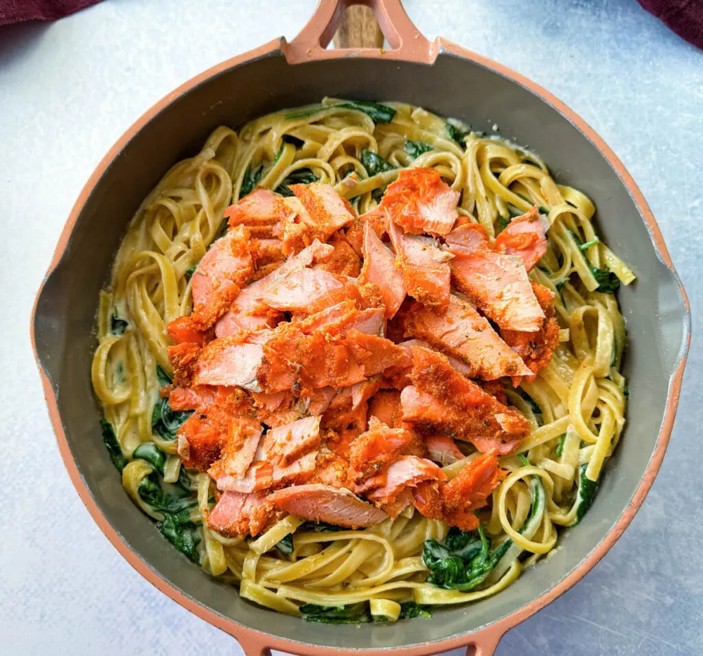 salmon Fettuccine Alfredo with spinach in a pan