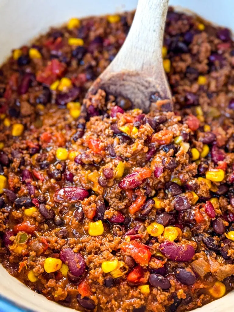 beef taco chili in a Dutch oven with a wooden spoon