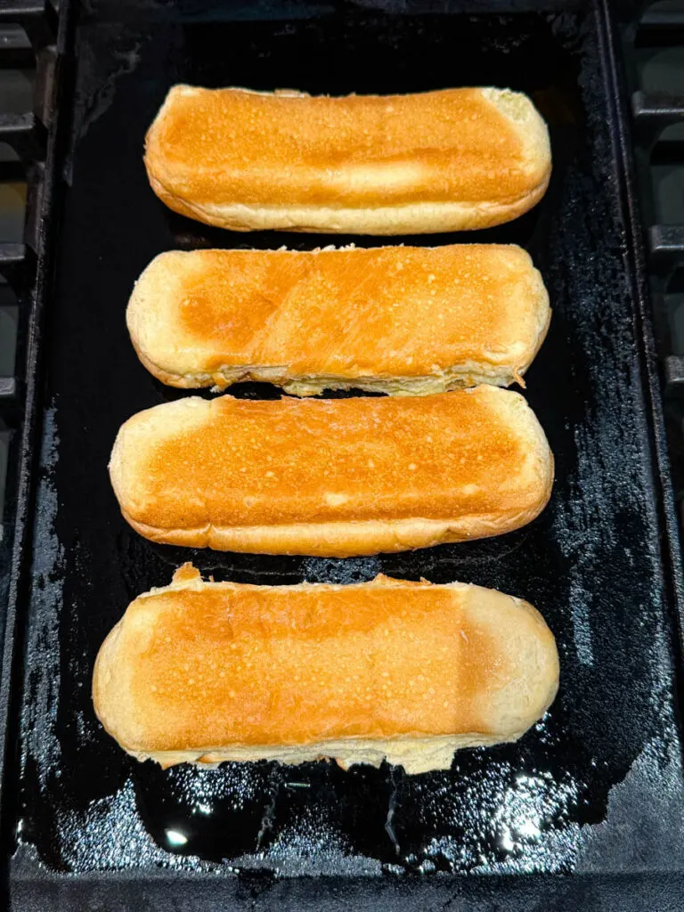 top sliced hot dog buns in a cast iron skillet