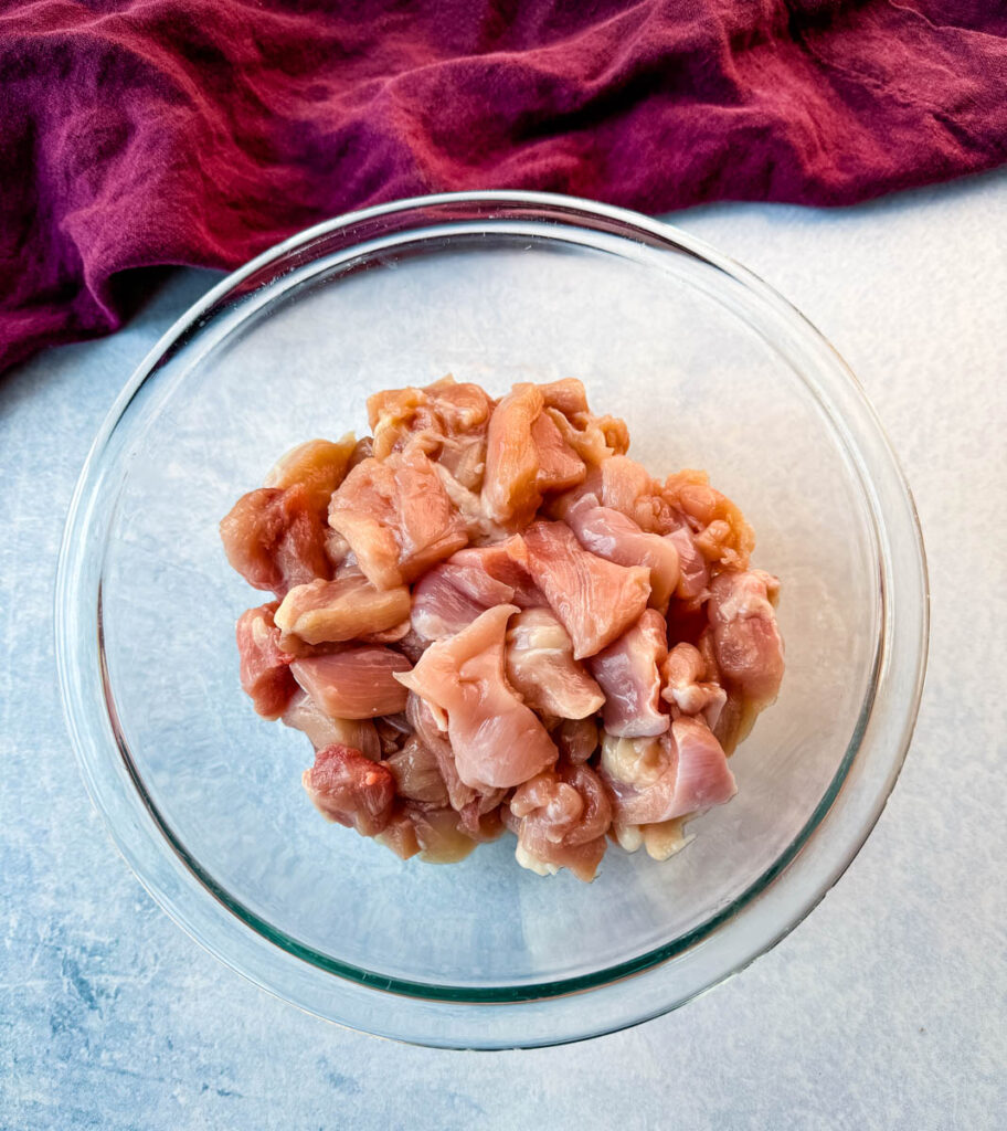 raw, diced chicken thighs in a glass bowl