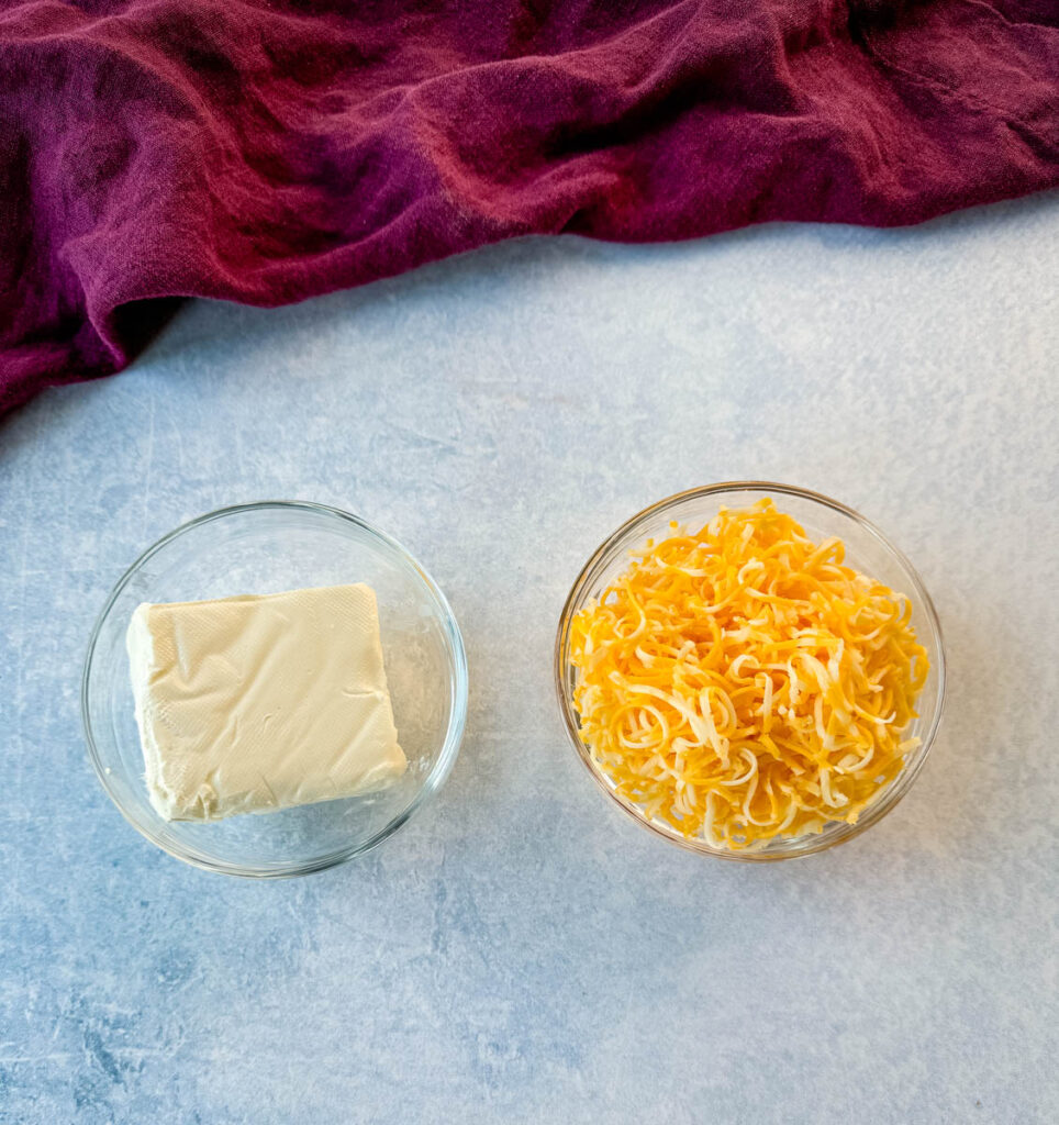 cream cheese and grated Colby Jack cheese in separate glass bowls