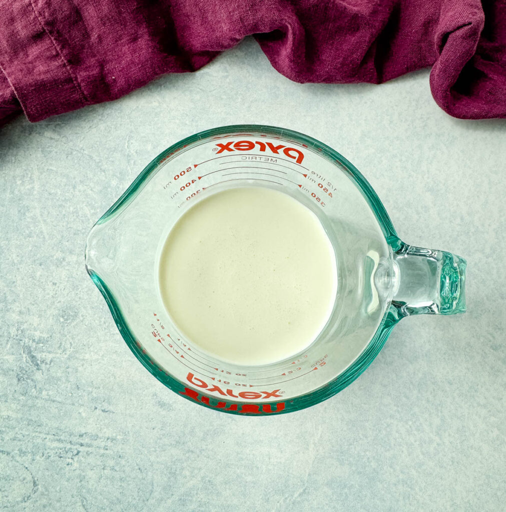 heavy whipping cream in a glass measuring cup