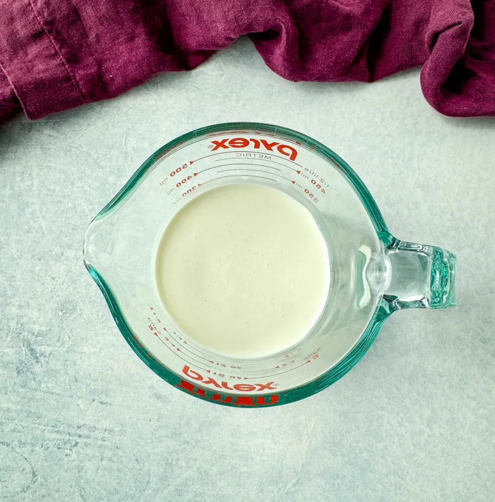 heavy whipping cream in a glass measuring cup