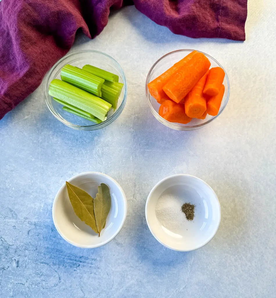 celery, carrots, bay leaves, salt, and pepper in separate bowls