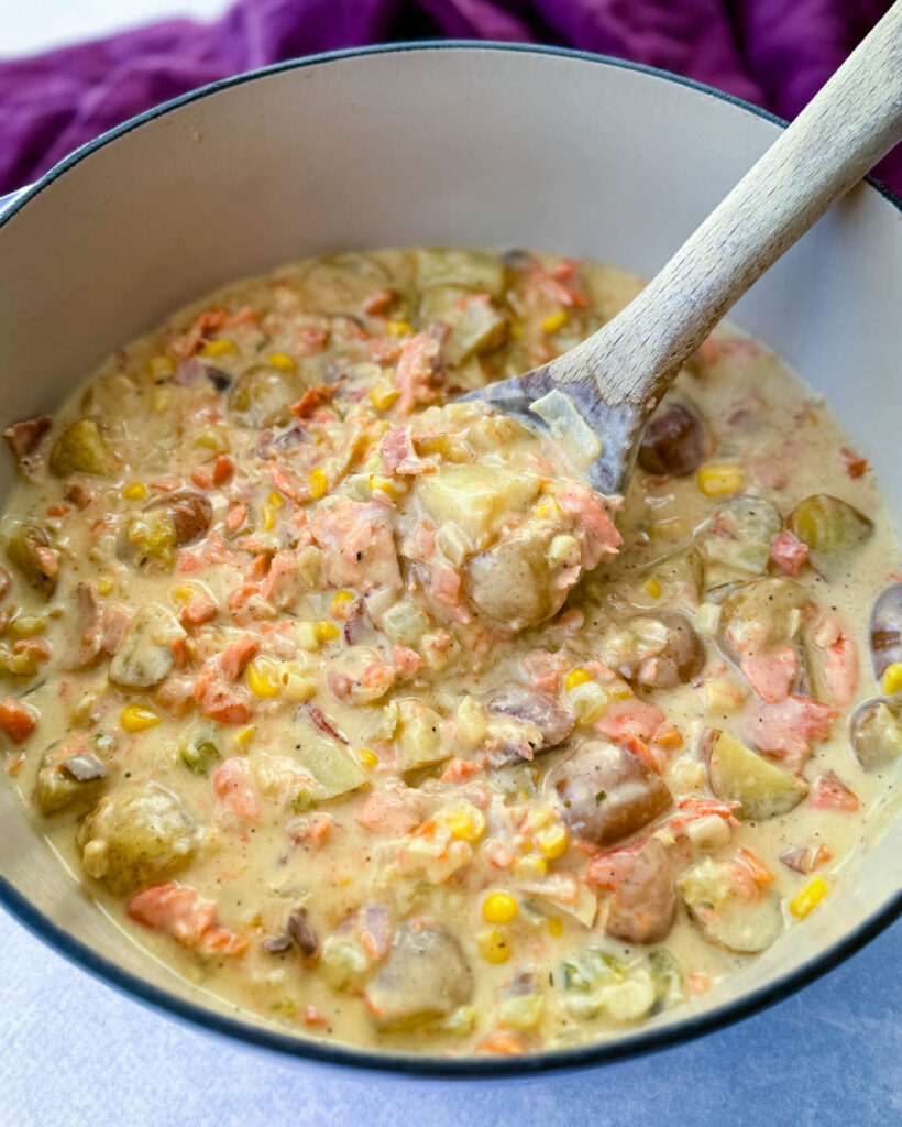 creamy salmon chowder with corn and potatoes in a Dutch oven