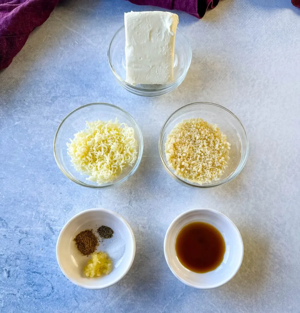 cream cheese, shredded parmesan, shredded mozzarella cheese, spices, and worcestershire sauce in separate glass bowls