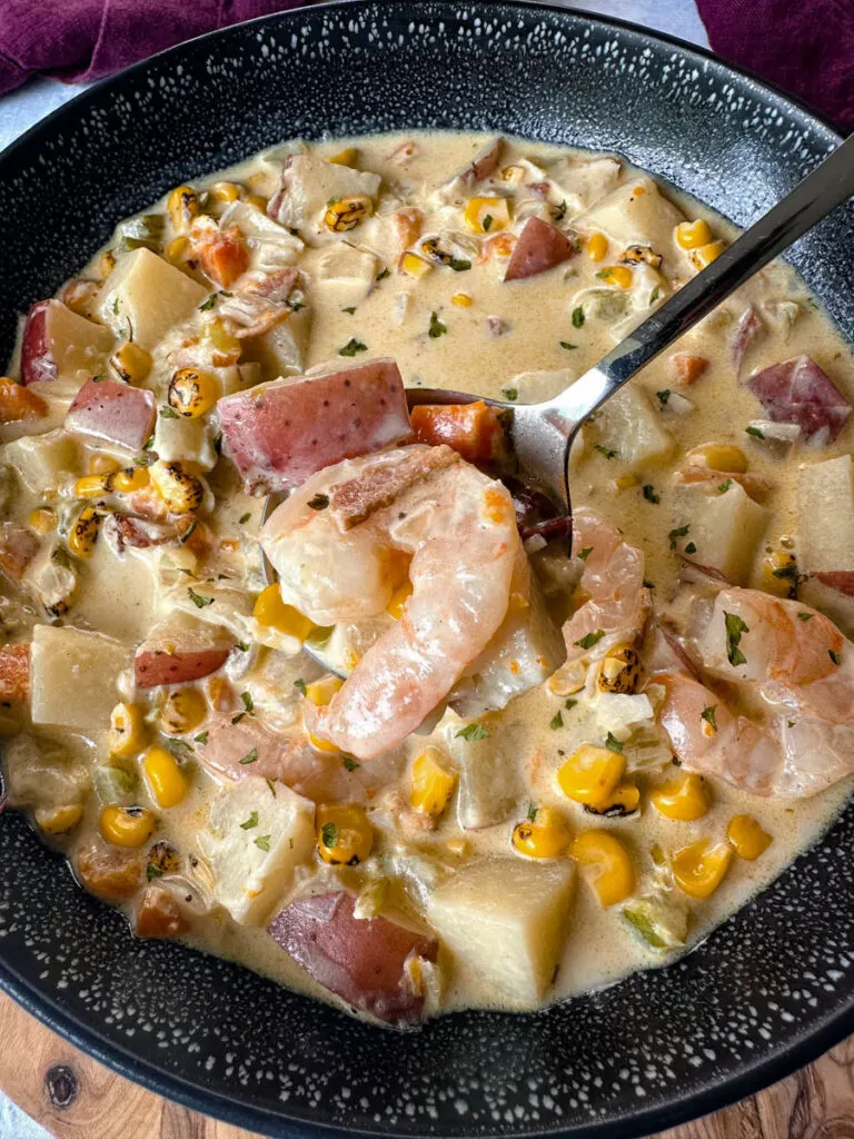 shrimp and corn chowder with bacon and potatoes in a black bowl